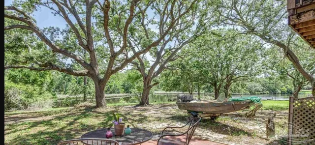a view of a lake with a yard and large trees