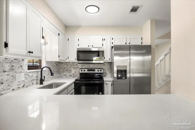 a kitchen with a sink stove and refrigerator