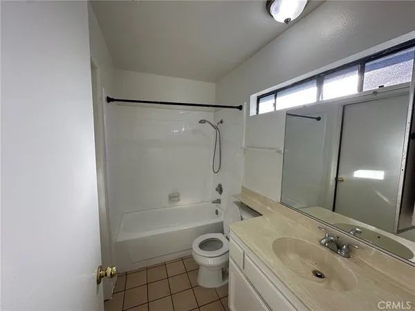 a bathroom with a bathtub shower sink vanity and toilet