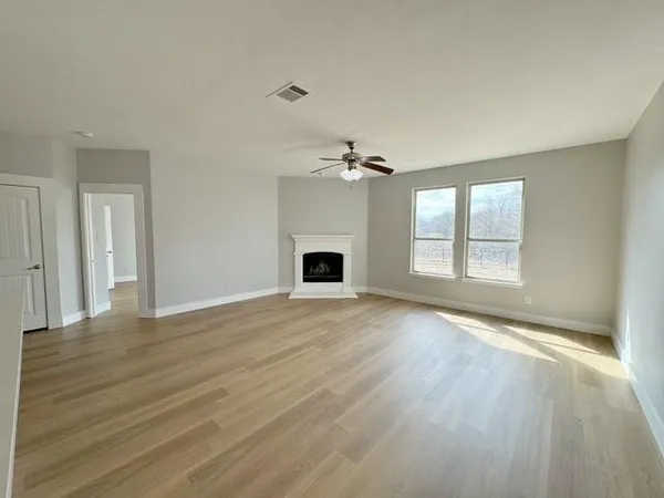 a view of an empty room with a fireplace and a window