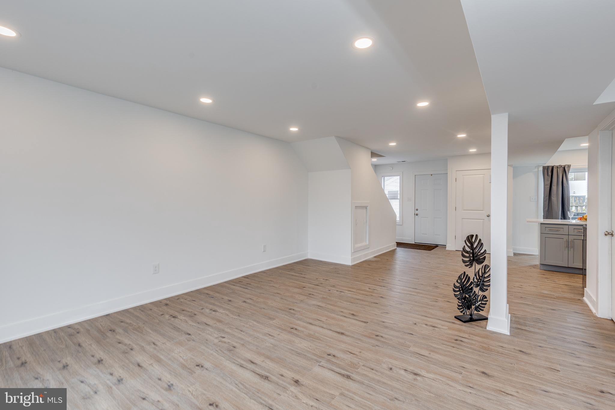 705 Mason Run Pine Hill, NJ 08021 - Photo 13 of 33 a view of an empty room with wooden floor and a kitchen