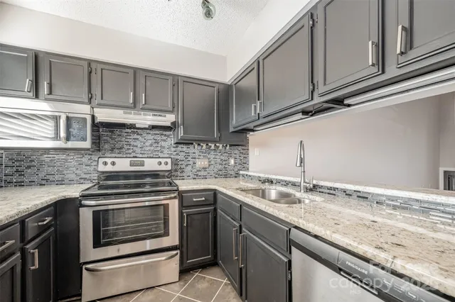 a kitchen with granite countertop cabinets stainless steel appliances and sink