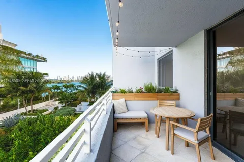 a balcony with wooden floor table and chairs