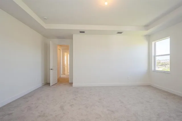 a view of a big room with windows and chandelier fan