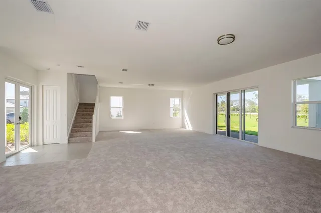 an empty room with windows and fireplace