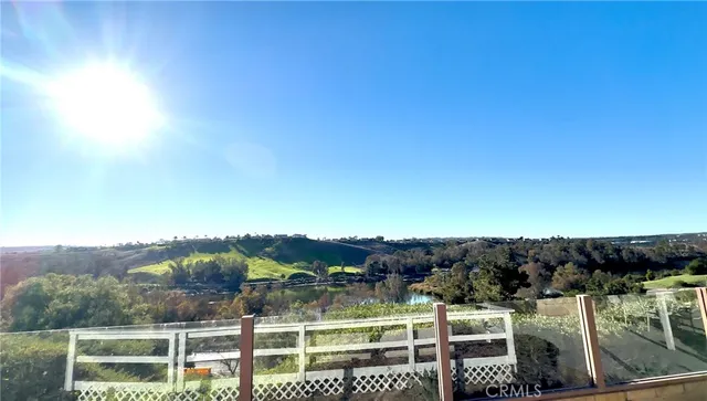 a view of a white house with a big yard and large trees