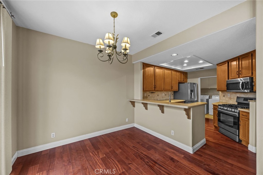 28677 La Azteca Laguna Niguel, CA 92677 - Photo 16 of 36 a white kitchen with a sink and dishwasher a stove top oven with wooden floor
