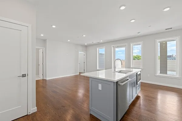a kitchen with a stove and a wooden floor