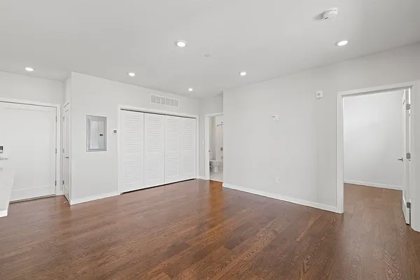 a view of an empty room with wooden floor