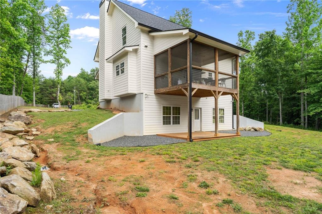 1300 Preacher Campbell Road Clarkesville, GA 30523 - Photo 29 of 34 a white house with a small yard and large trees