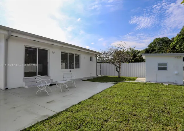 a backyard of a house with table and chairs