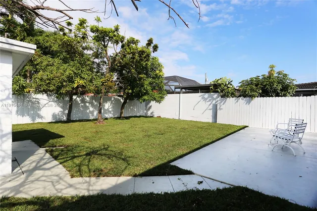 a view of a swimming pool with a yard and plants