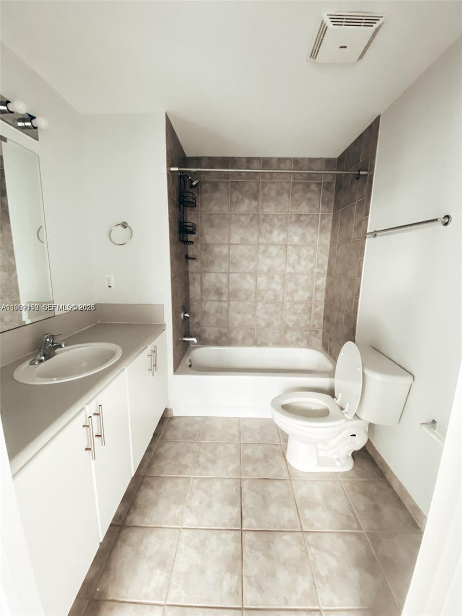 455 Northeast 25th Street, Unit 809 Miami, FL 33137 - Photo 11 of 18 a bathroom with a granite countertop sink a toilet and shower