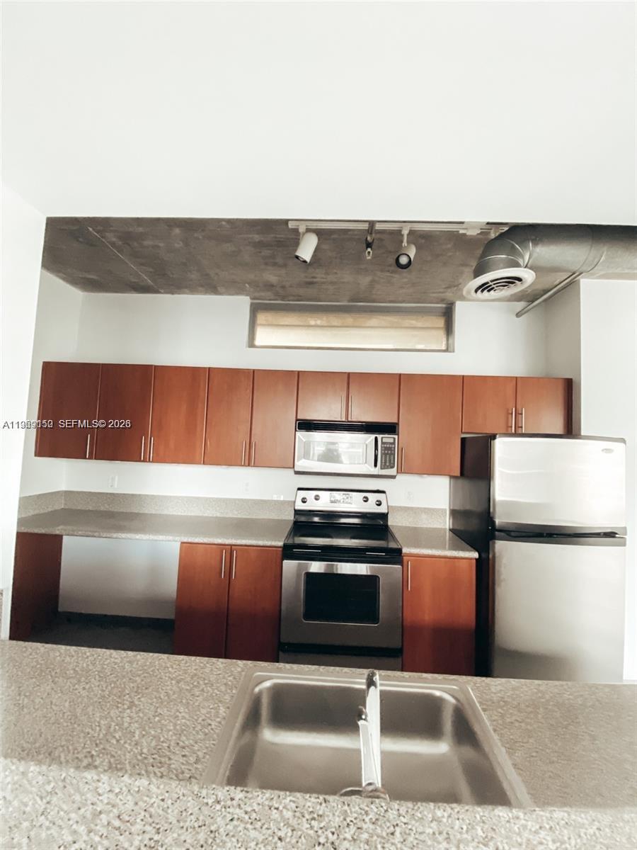 455 Northeast 25th Street, Unit 809 Miami, FL 33137 - Photo 7 of 18 a kitchen with stainless steel appliances granite countertop a sink and a stove