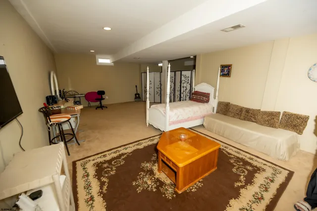 a living room with furniture pool table and a flat screen tv