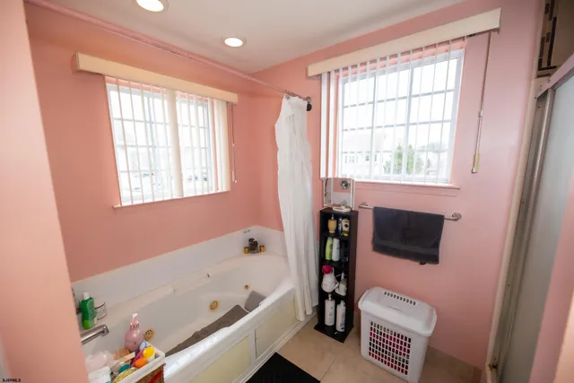 a bathroom with a bathtub a sink a toilet and a window