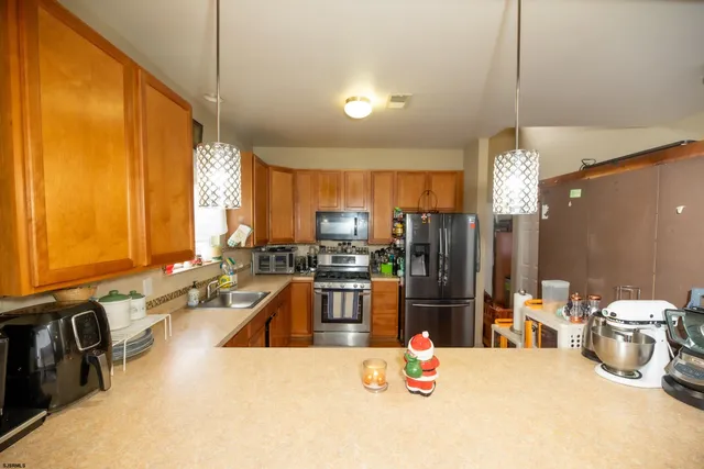 a kitchen with sink refrigerator and microwave