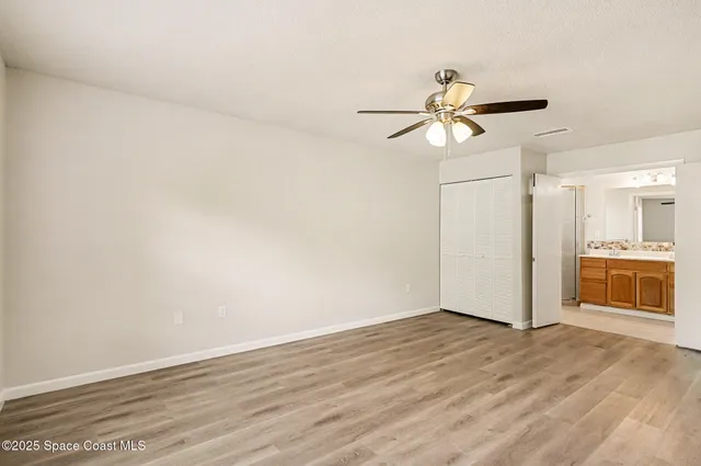 a view of a kitchen with wooden floor and a ceiling fan