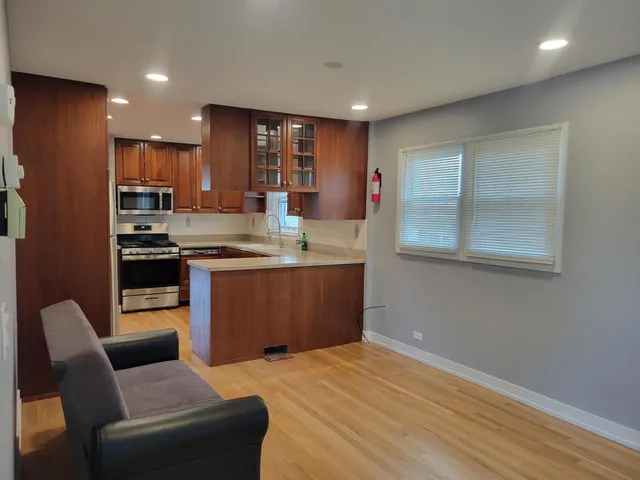 a kitchen with stainless steel appliances granite countertop a stove top oven a sink and a refrigerator