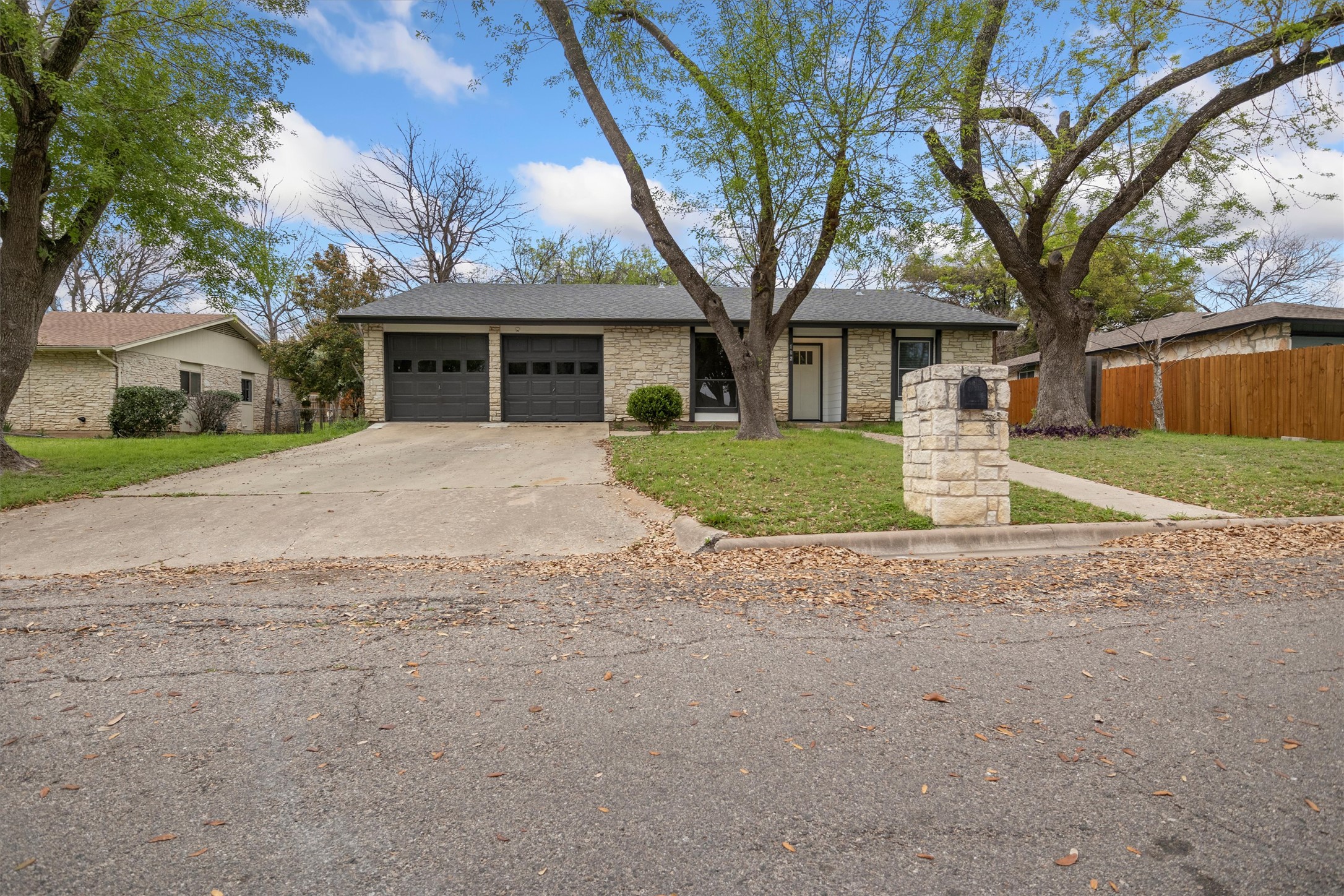 502 Pin Tail Lane Taylor, TX 76574 - Photo 26 of 26 Stone facade residence with a two-car garage, mature trees, and a concrete driveway
