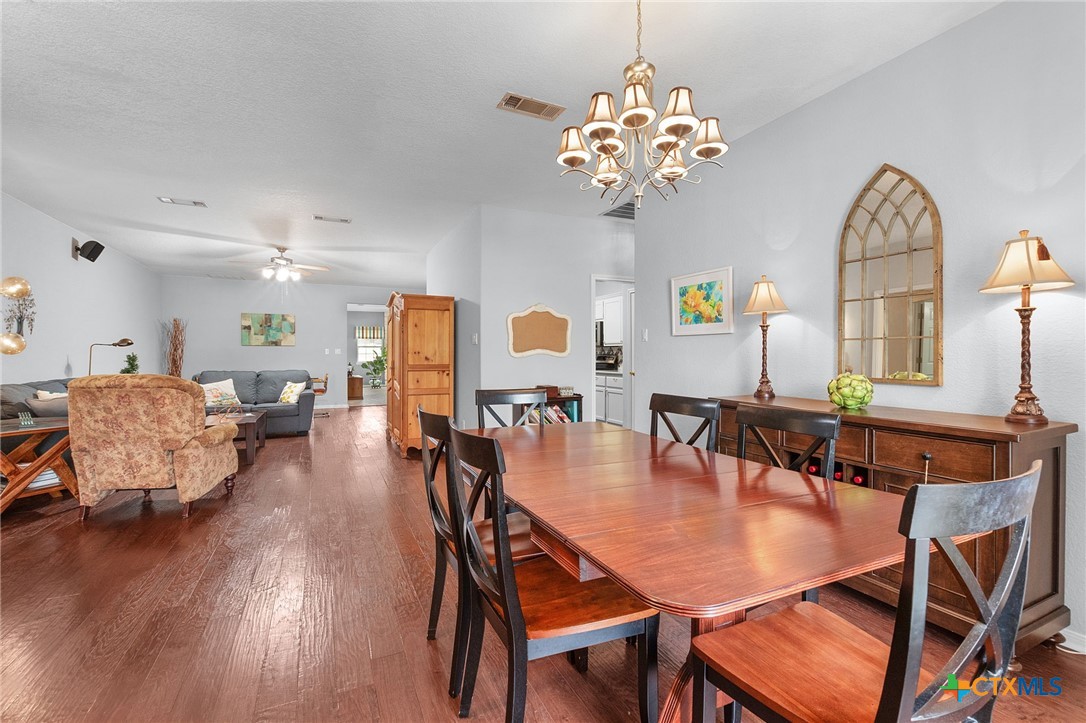812 Taylor Creek Road Copperas Cove, TX 76522 - Photo 11 of 44 a dining room with wooden floor a chandelier a wooden table and chairs