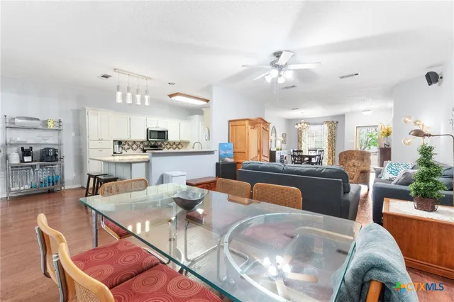 a living room with furniture kitchen view and a chandelier