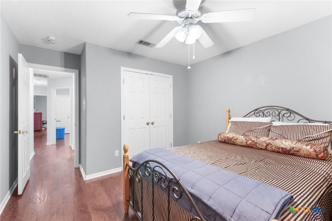 812 Taylor Creek Road Copperas Cove, TX 76522 - Photo 23 of 44 a bedroom with a large bed and a chandelier