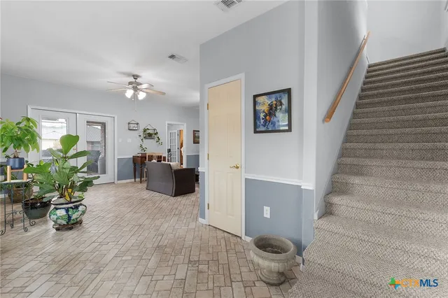 a view of a hallway with dining room and furniture