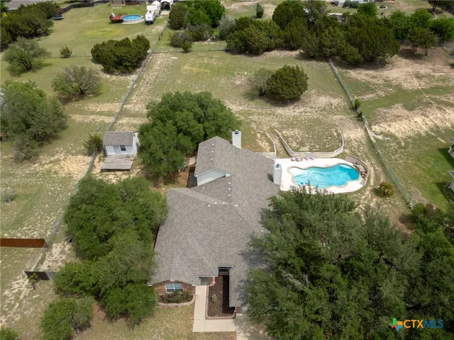 an aerial view of a house with yard and parking