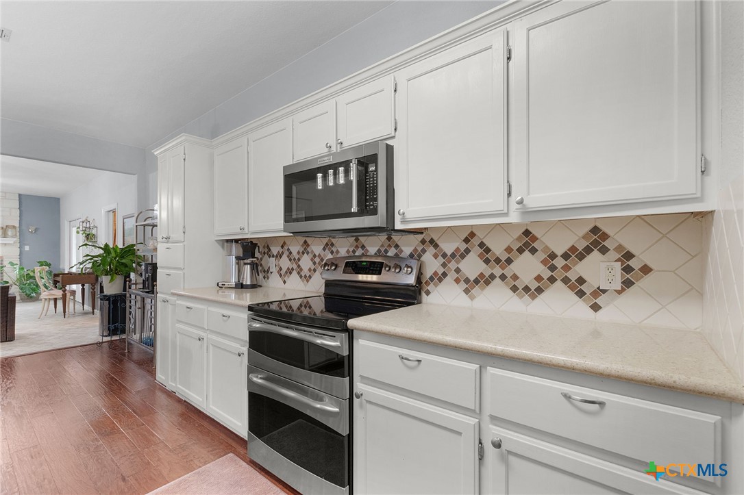 812 Taylor Creek Road Copperas Cove, TX 76522 - Photo 6 of 44 a kitchen with granite countertop white cabinets and white appliances