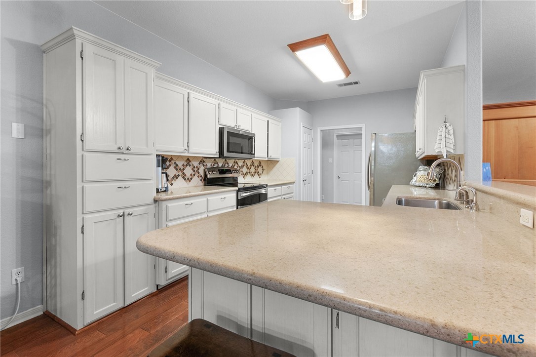 812 Taylor Creek Road Copperas Cove, TX 76522 - Photo 8 of 44 a kitchen with stainless steel appliances a stove refrigerator sink and cabinets