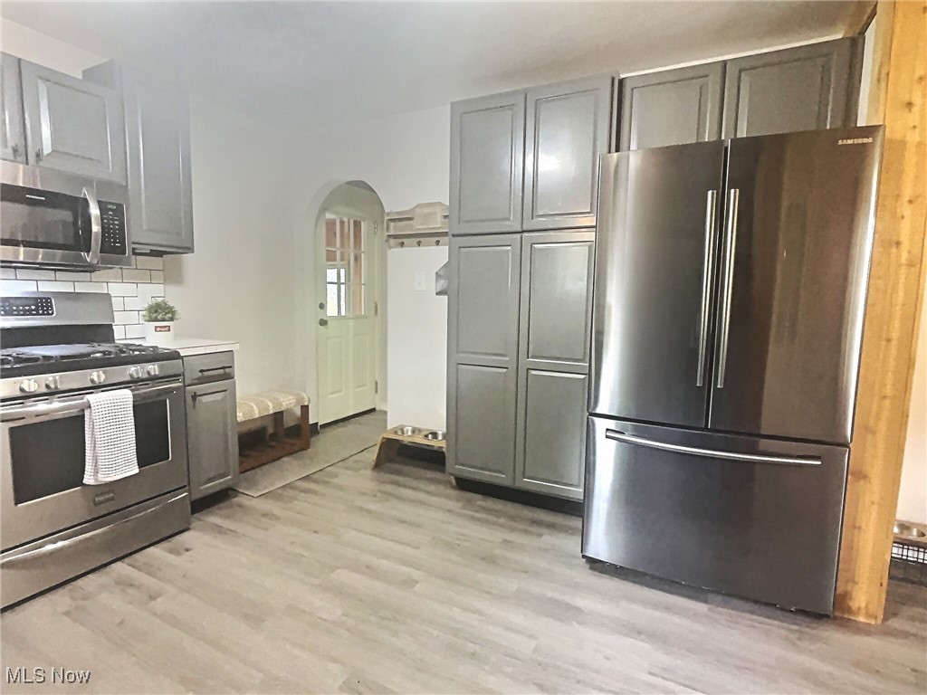 3688 Easton Road Norton, OH 44203 - Photo 17 of 37 Kitchen featuring tasteful backsplash, gray cabinets, stainless steel appliances, and light hardwood / wood-style floors