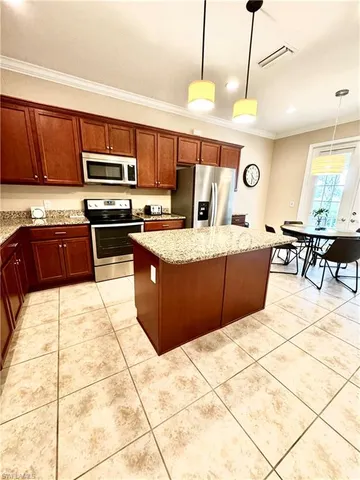 a large kitchen with stainless steel appliances granite countertop a stove granite counter tops and white cabinets