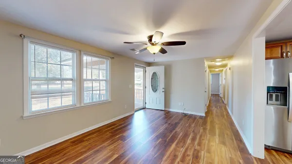 a view of a hallway with a door and wooden floor