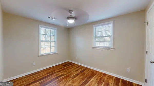 a view of an empty room with wooden floor