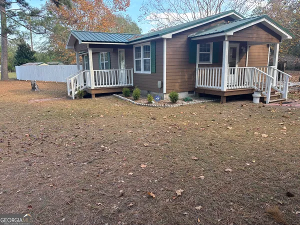 a view of a house with a yard and wooden fence