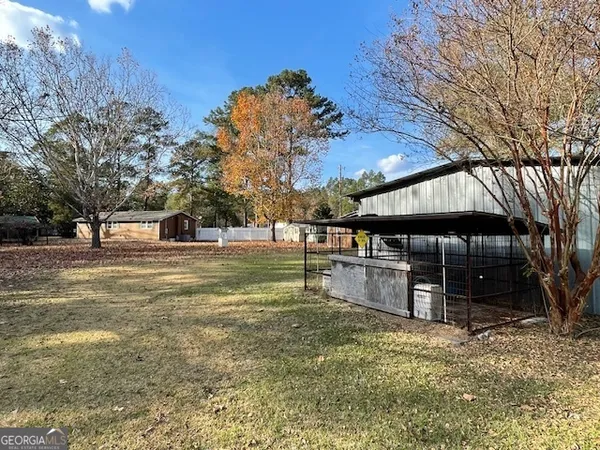 a view of dirt yard with large trees