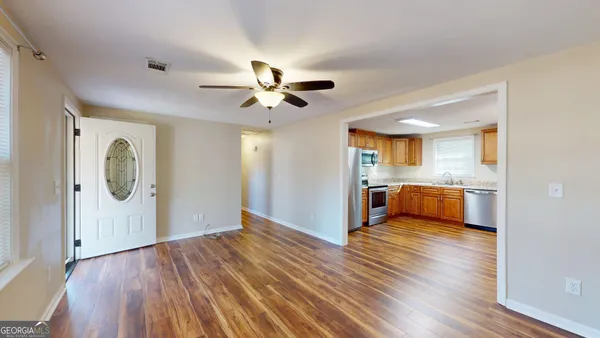a view of a kitchen counter space a sink wooden floor and a window
