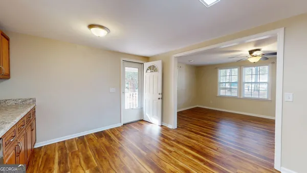 a kitchen with stainless steel appliances granite countertop a refrigerator a stove top oven a sink dishwasher and wooden floor