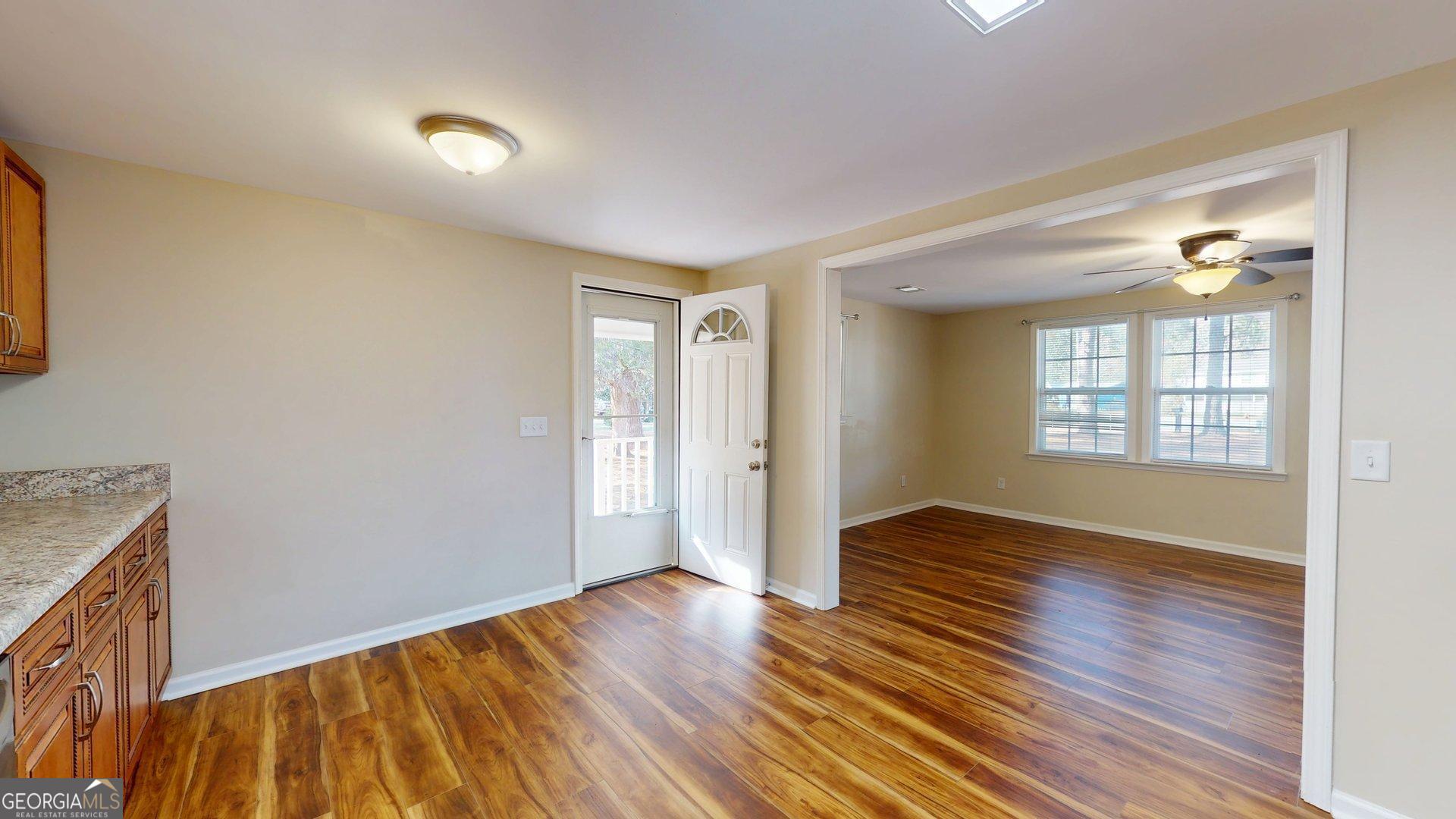 142 Bill Brown Road Pembroke, GA 31321 - Photo 9 of 33 an empty room with wooden floor and windows