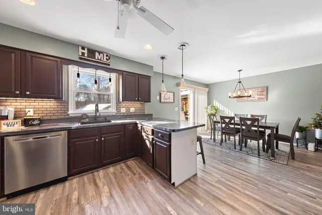 a kitchen with stainless steel appliances granite countertop a sink cabinets and wooden floor