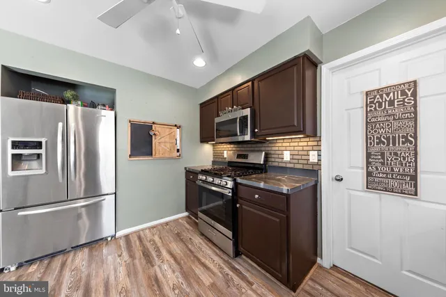 a kitchen with stainless steel appliances granite countertop a refrigerator a stove top oven a sink and dishwasher