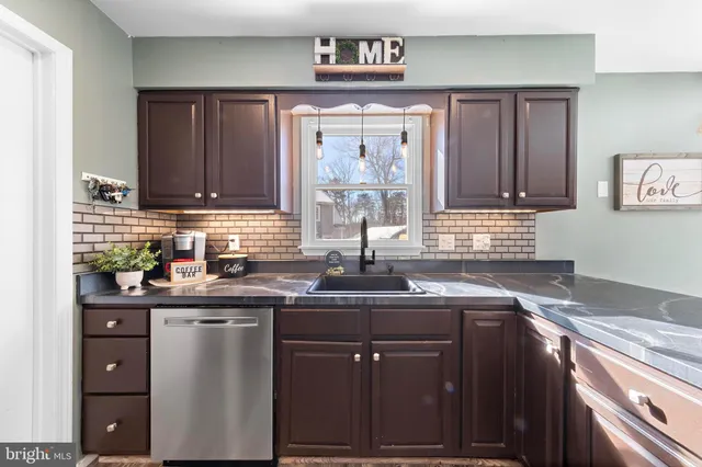 a kitchen with stainless steel appliances granite countertop a sink stove and cabinets
