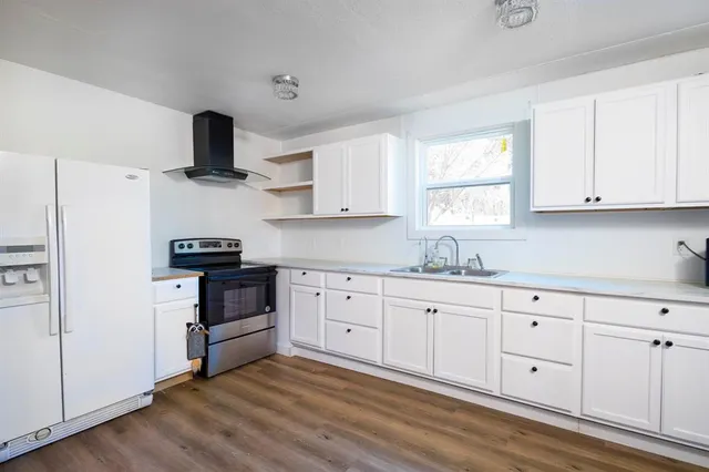 a kitchen with white cabinets and appliances