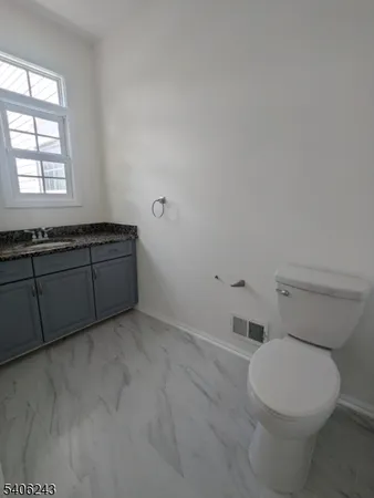 a bathroom with a toilet a sink and mirror