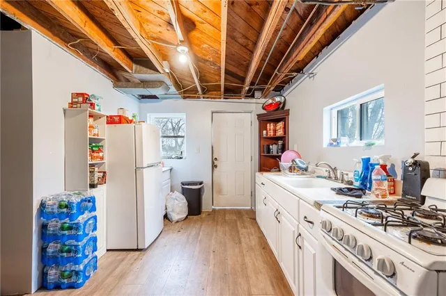 a kitchen with stainless steel appliances granite countertop a refrigerator a stove and a wooden floors