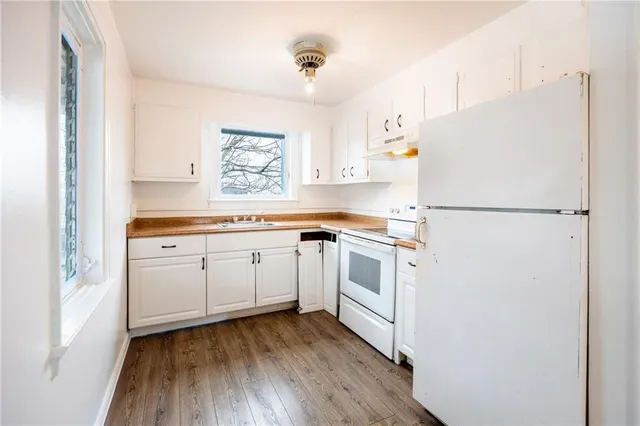 a kitchen with white cabinets and white appliances