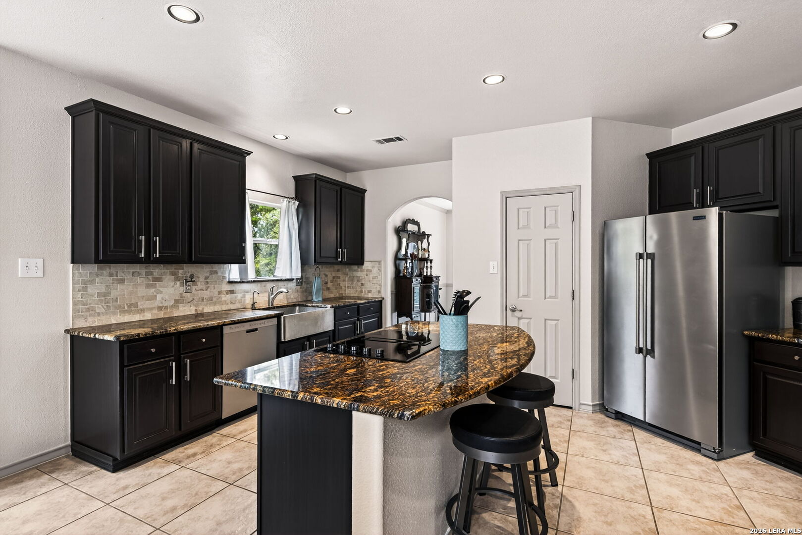 17431 Helotes Spring Road Helotes, TX 78023 - Photo 16 of 50 a kitchen with granite countertop cabinets a refrigerator and a sink