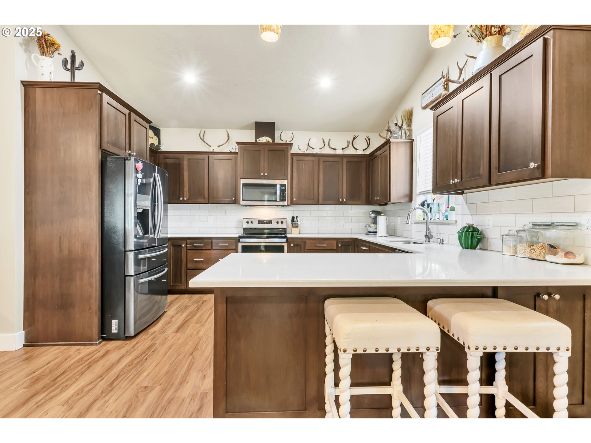 24701 Nottingham Street Veneta, OR 97487 - Photo 5 of 28 a kitchen with stainless steel appliances kitchen island granite countertop a refrigerator a stove and a sink