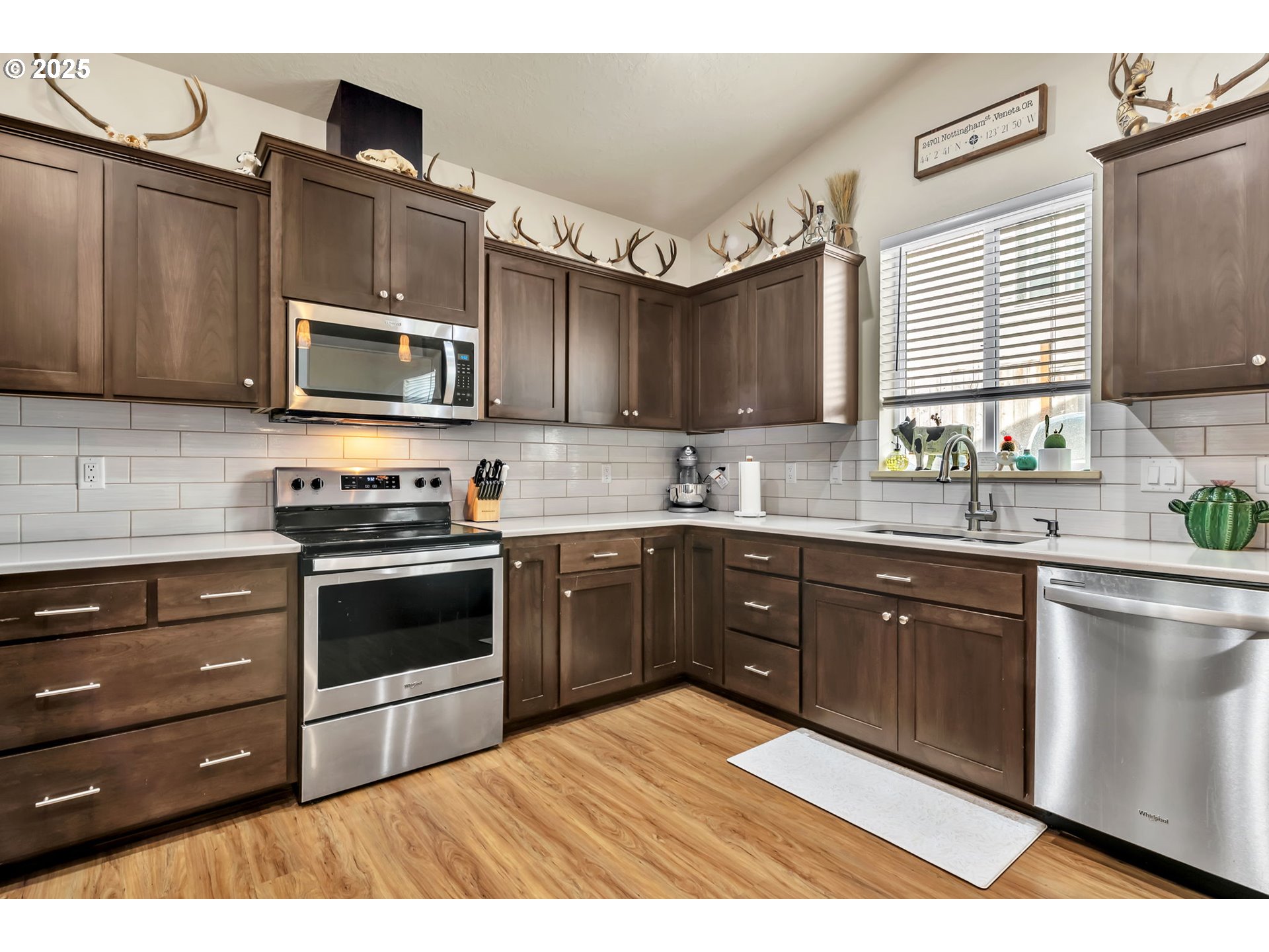 24701 Nottingham Street Veneta, OR 97487 - Photo 6 of 28 a kitchen with stainless steel appliances kitchen island granite countertop a sink stove and microwave